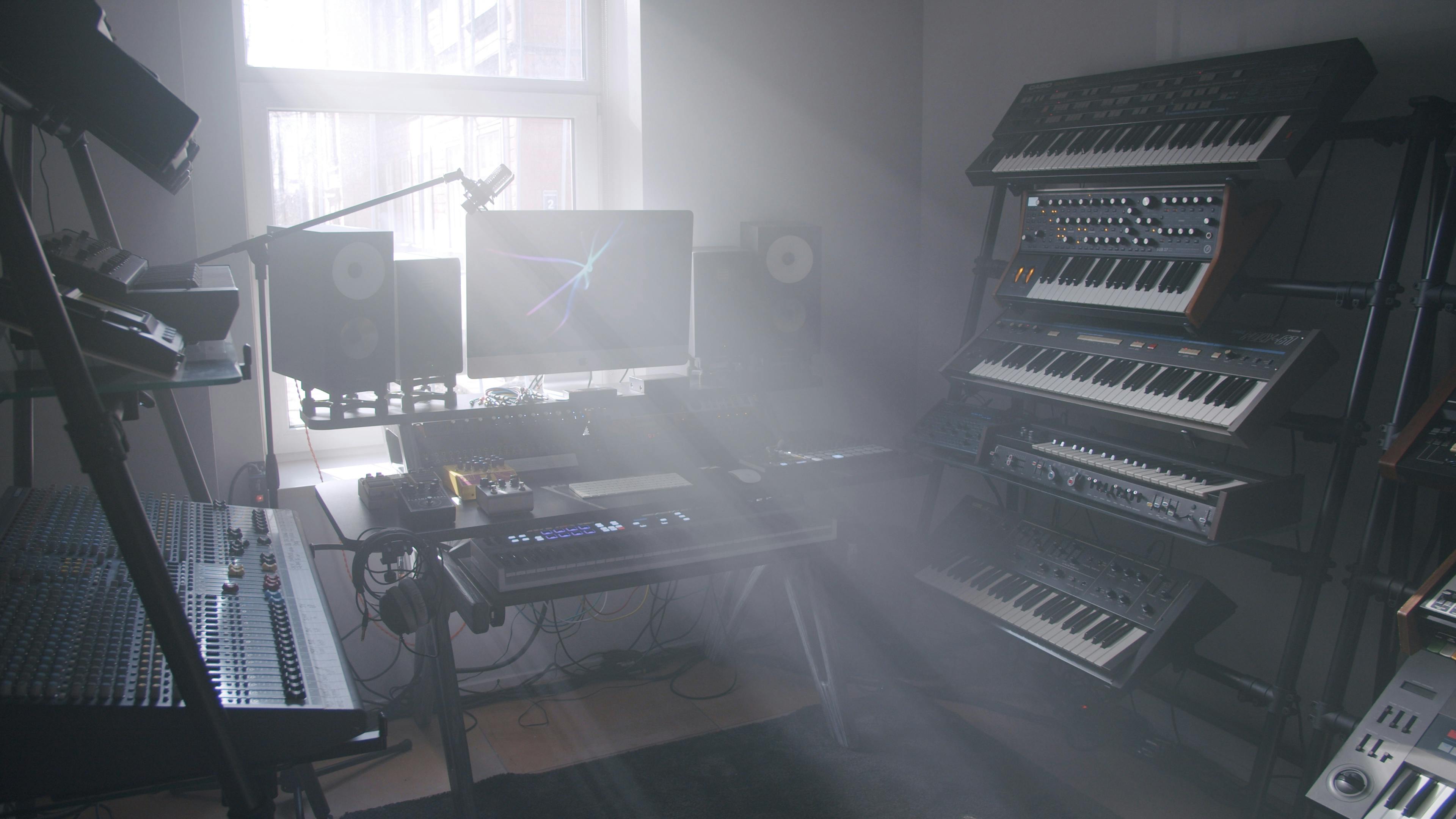 Studio de productie muzicala echipat cu sintetizatoare si monitoare audio unde un tratament acustic asigura claritatea sunetului
